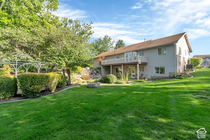 Expansive lawn with mature trees and a stone fire pit