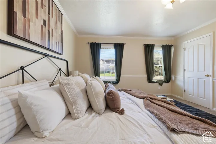 Room featuring neutral wall paint, white chair rail molding, crown molding, and two windows with horizontal blinds