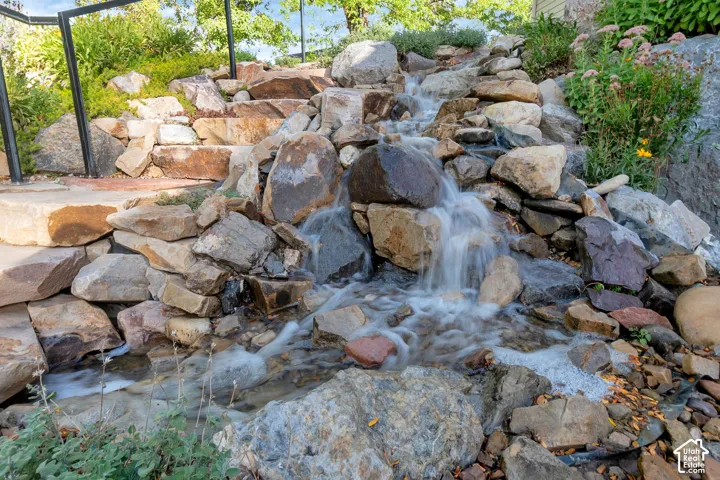 Rock water feature with natural stone steps and integrated plantings