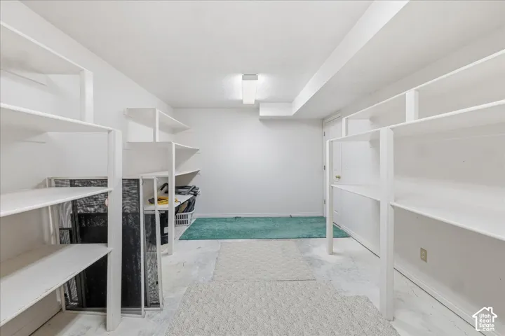 Storage space featuring multiple levels of built-in shelving and overhead lighting
