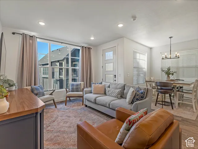 Open-concept living space featuring recessed lighting, a multi-pane window with drapery, and wood-finish flooring