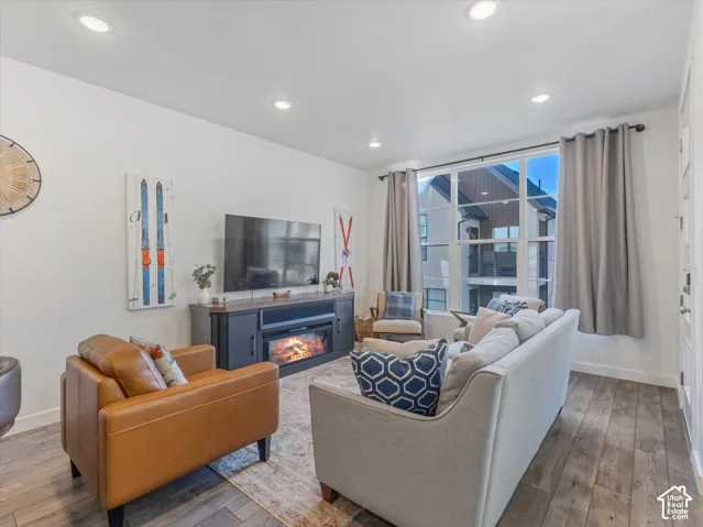 Recessed ceiling lighting, wood-finish flooring, large multi-pane window, built-in entertainment console with electric fireplace