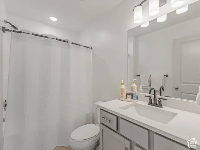 Modern vanity with gray cabinetry, integrated sink, and dark bronze faucet