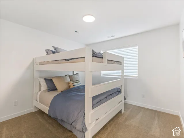 White walls, recessed ceiling lighting, and carpeted flooring