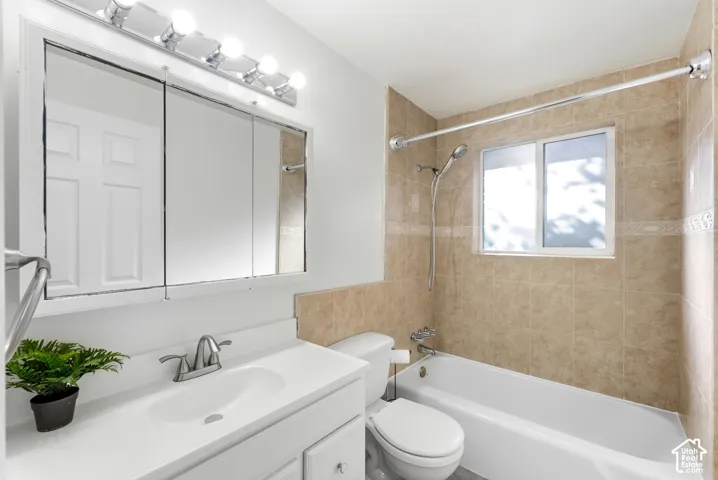 White vanity with integrated sink, chrome faucet, and mirrored medicine cabinet