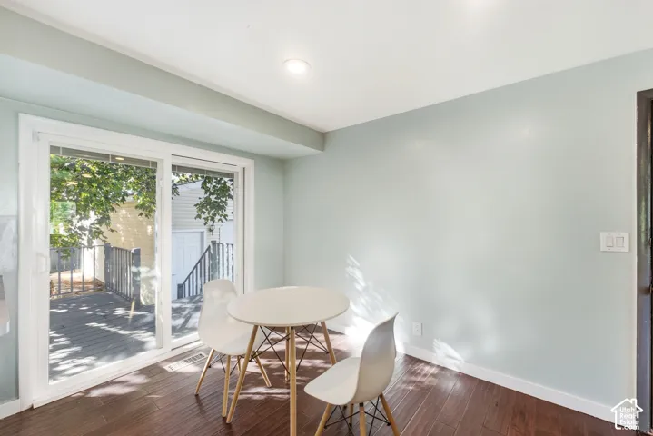 Sliding glass door, recessed ceiling lighting, dark wood-finish flooring, light-colored walls, white trim
