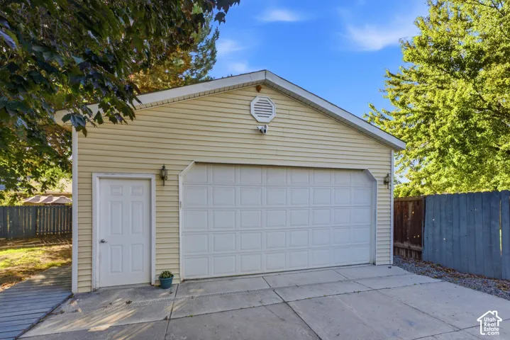 Two-car garage with a paneled door, exterior lighting fixtures, and a side entry door