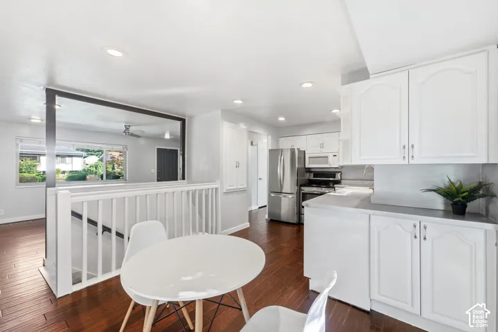 Kitchen featuring white cabinetry, stainless steel appliances, recessed lighting, and wood-finish flooring
