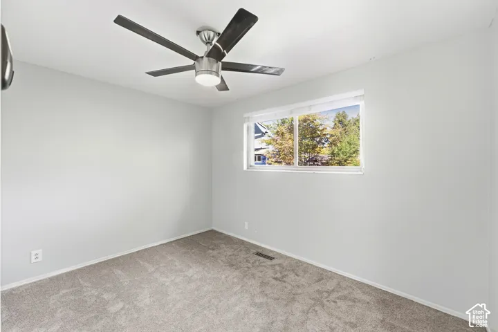 Recessed window with white trim, a modern ceiling fan, wall-to-wall carpeting, and light-toned walls