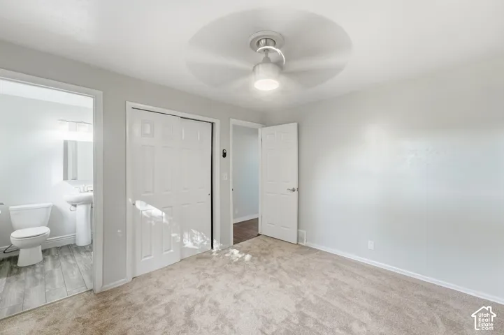 Recessed lighting, ceiling fan, and light-toned carpet
