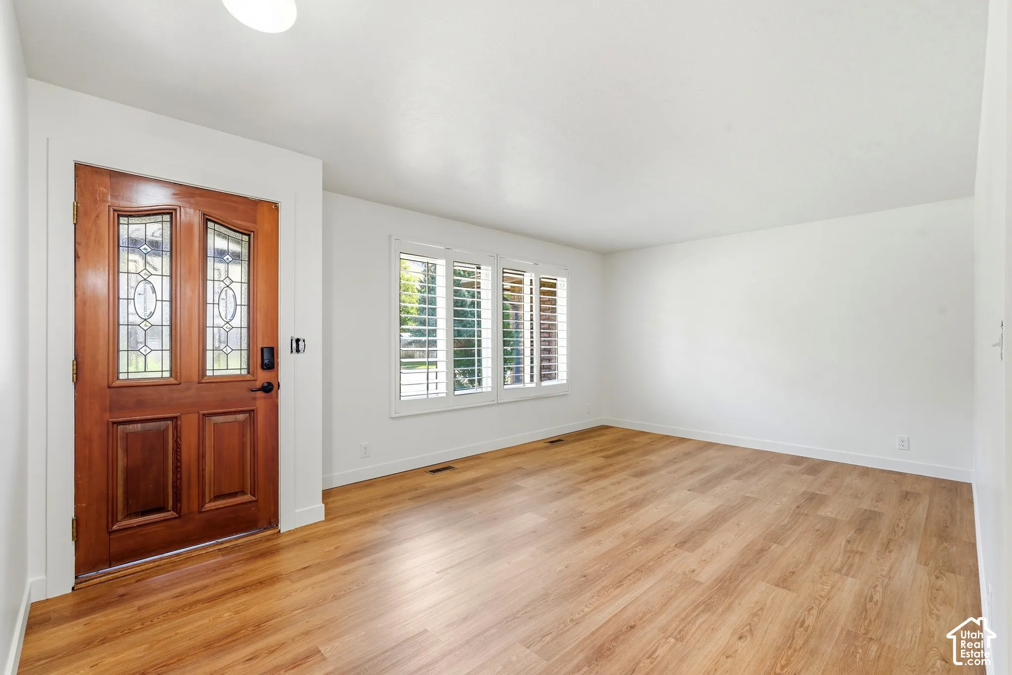 Formal Living Room. Hardwood-finish flooring, white walls, and a recessed ceiling light