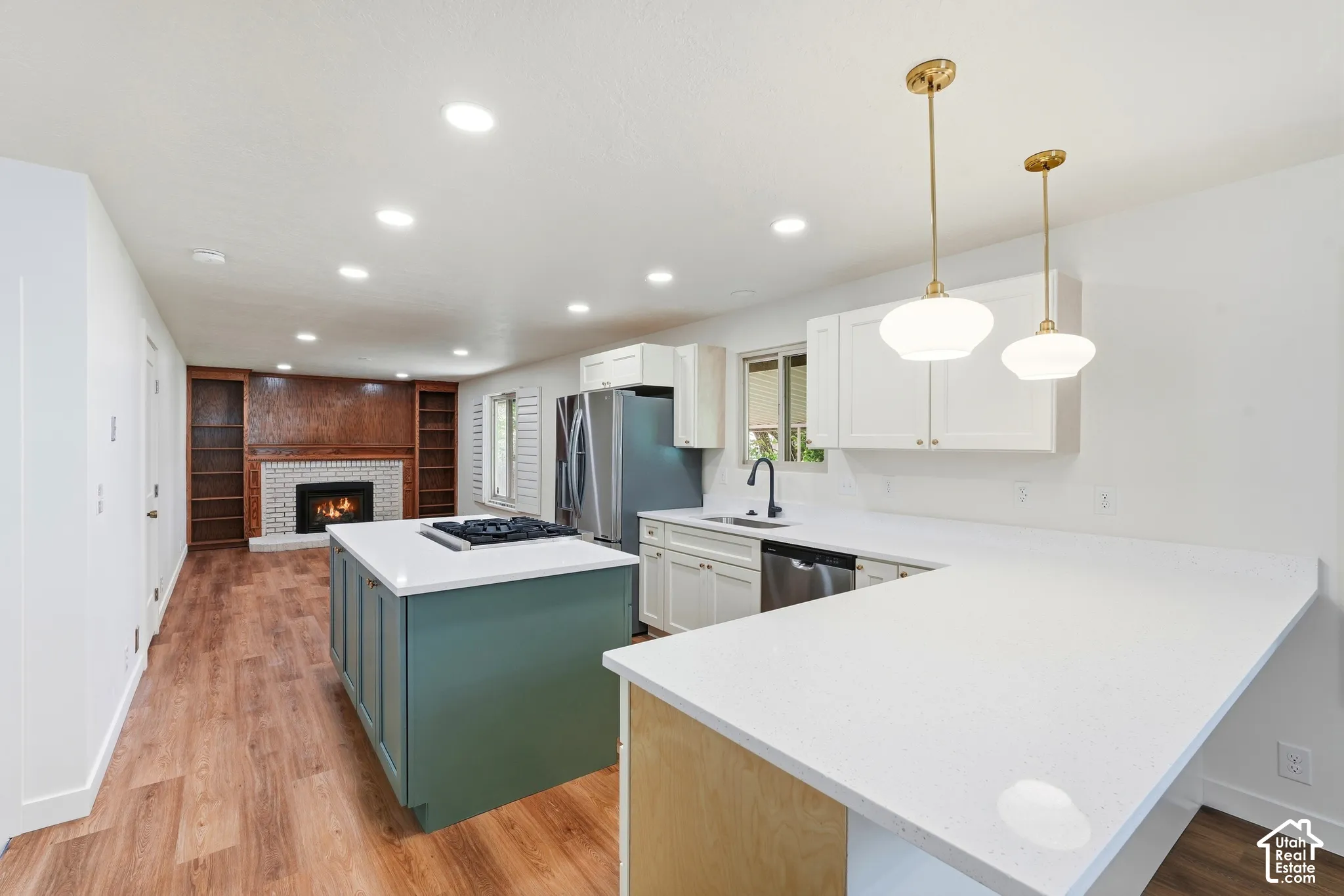 Modern kitchen featuring white cabinetry, light-toned countertops, and two pendant lights