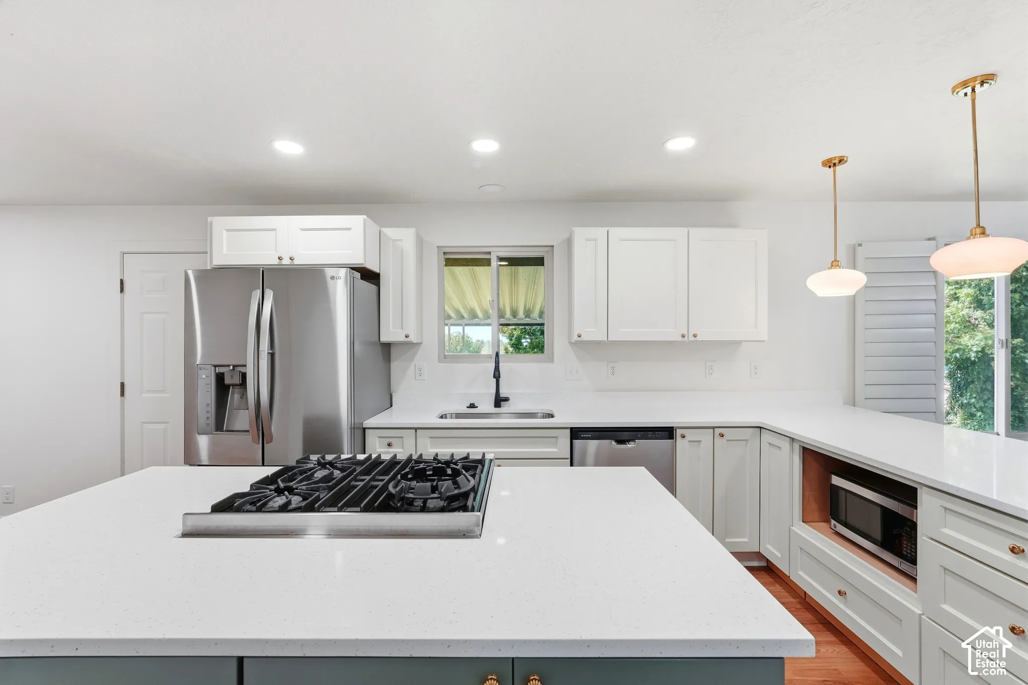 Kitchen featuring white upper cabinetry, light green lower cabinetry, and white countertops