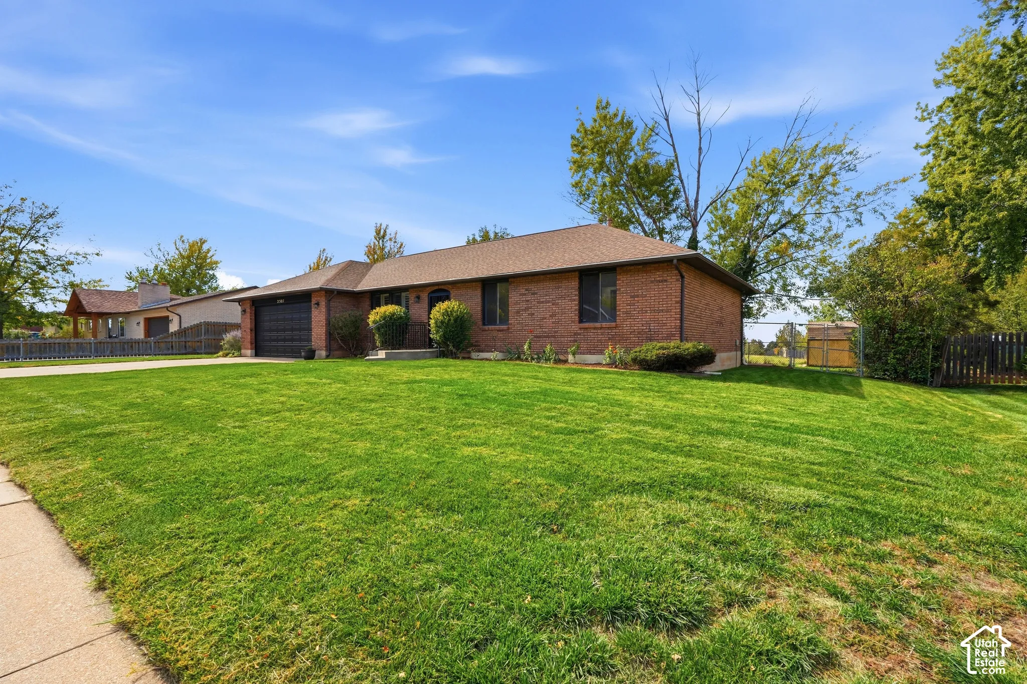 Brick exterior with a dark roof and dark garage door