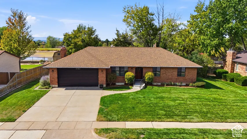 Brick exterior with a shingle roof and an attached garage