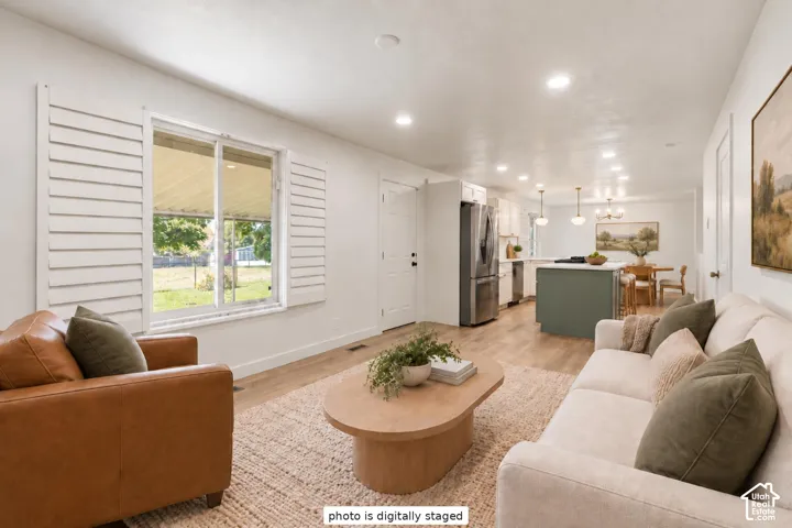 Recessed lighting, wood-finish flooring, plantation shutters, and a kitchen island with built-in cabinetry