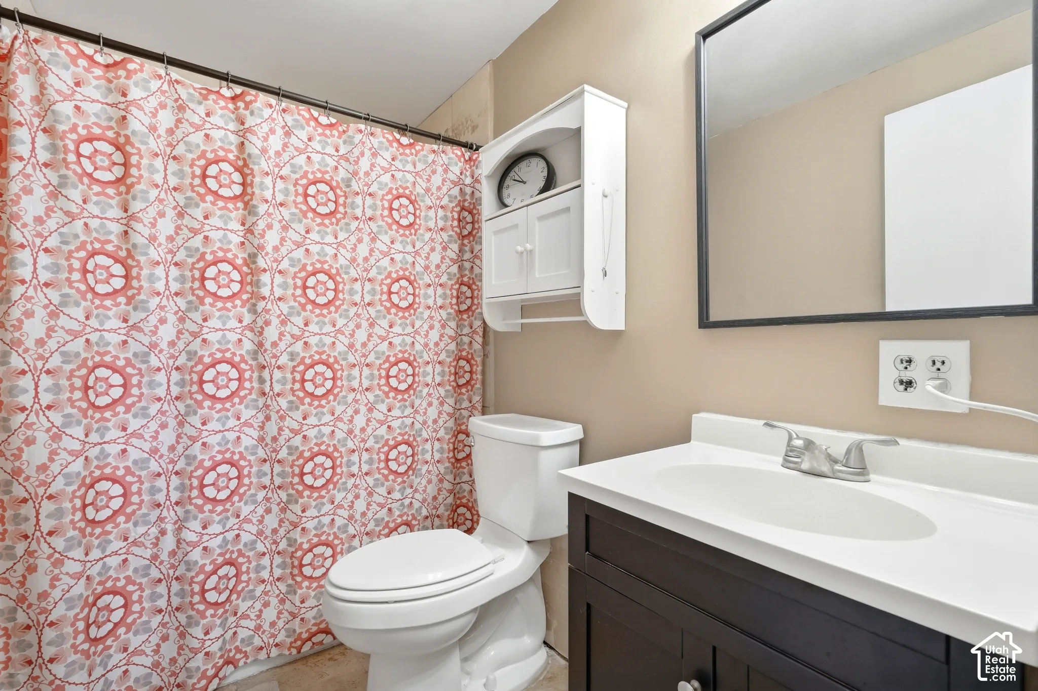 Dark wood-finish vanity with an integrated white sink, wall-mounted mirror, and a white wall cabinet