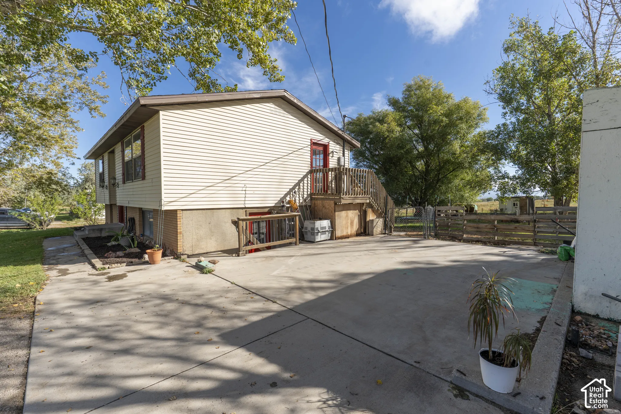 Split-level home featuring light-colored siding and a concrete driveway