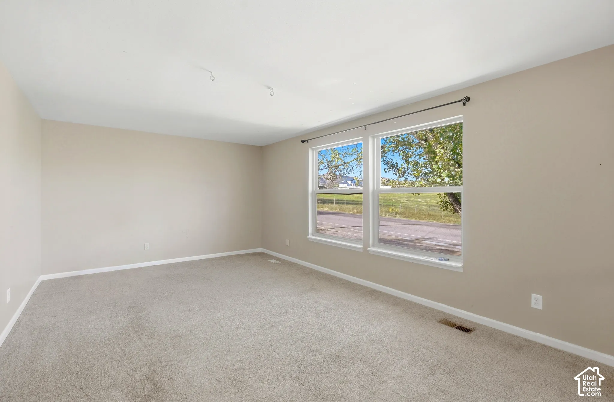 Neutral-toned walls complement the light-colored carpeting