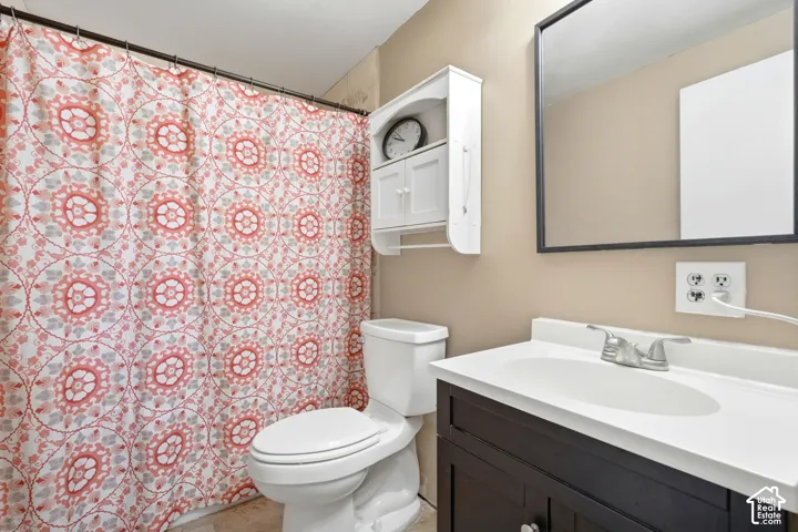 Dark wood-finish vanity with an integrated white sink, wall-mounted mirror, and a white wall cabinet