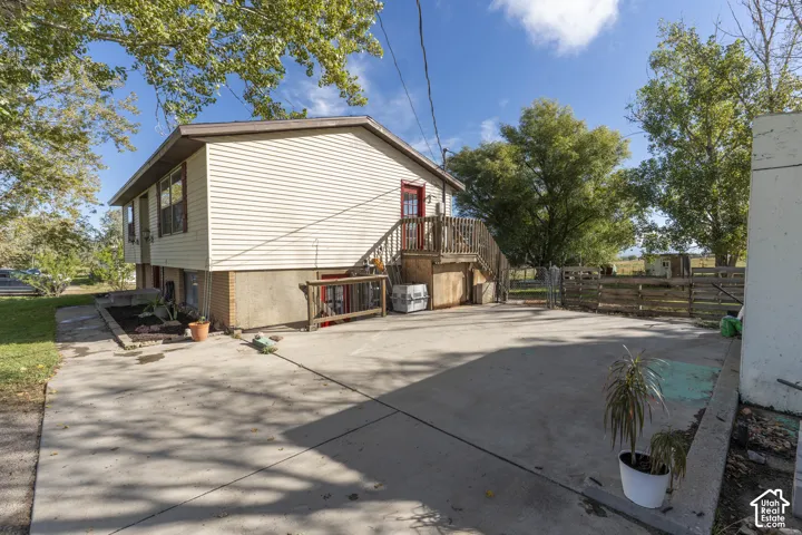Split-level home featuring light-colored siding and a concrete driveway