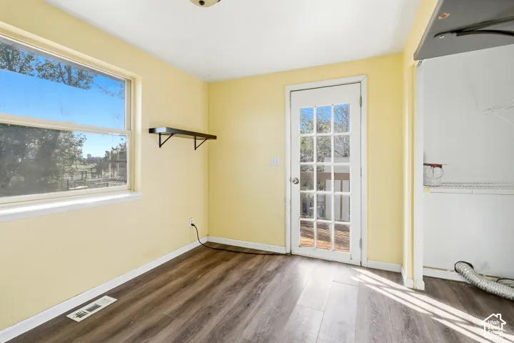 Wood-finish flooring, white trim, single-pane window, white French door, built-in shelving