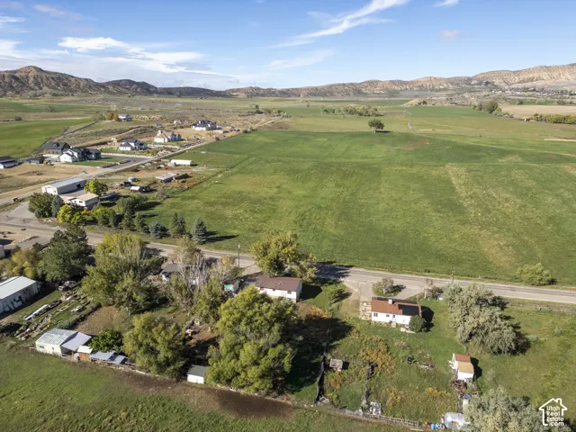 Expansive green fields with distant mountainous terrain under a clear sky