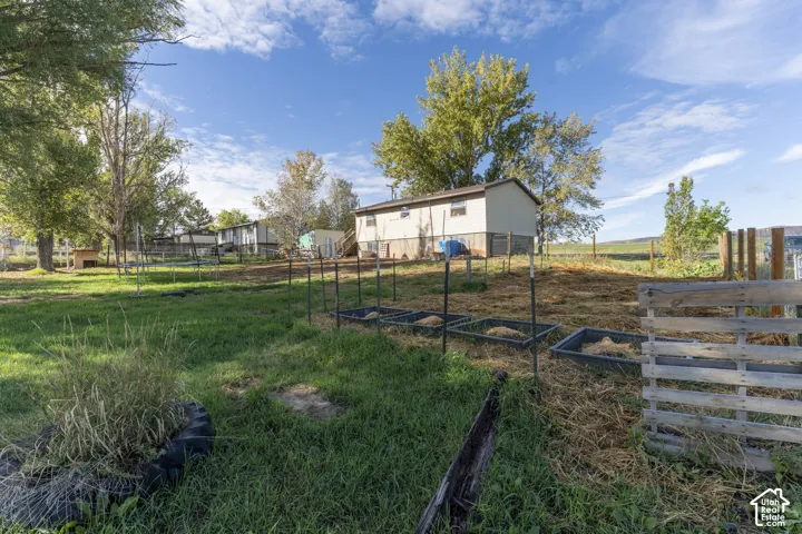 Expansive lot featuring a structured garden area with raised beds and a mature tree line