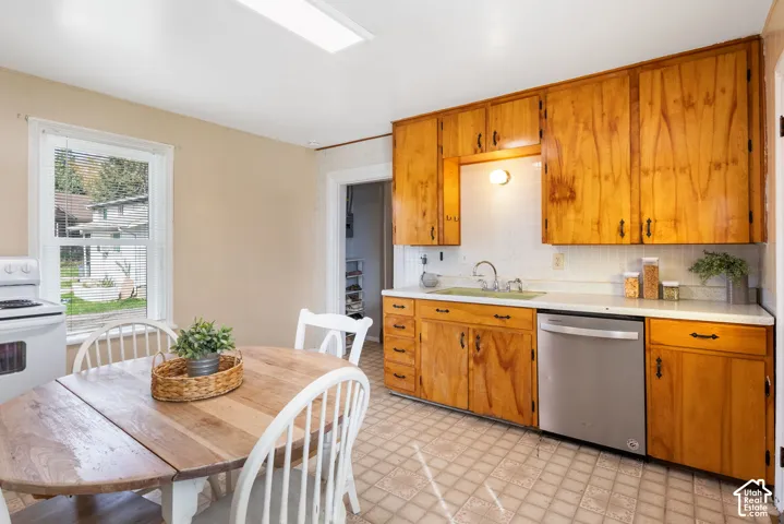 Wood cabinetry featuring black hardware, white countertops, and a tile backsplash