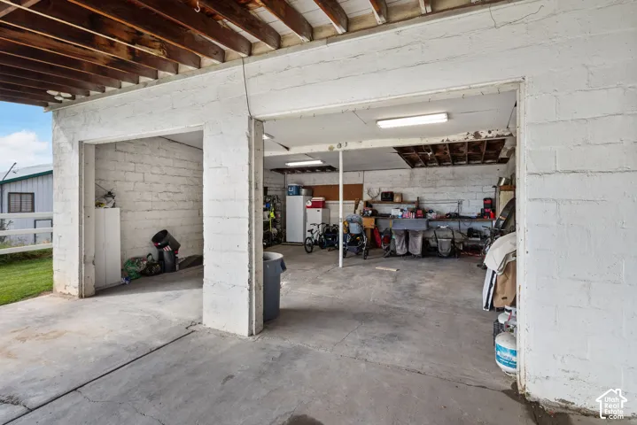 Exposed wood beam ceiling, concrete flooring, concrete block walls, and overhead lighting
