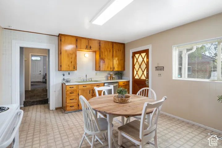 Kitchen featuring wood cabinetry, a window with blinds, and tiled flooring