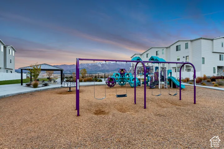 Community playground with multiple play structures, swings, and a covered picnic area