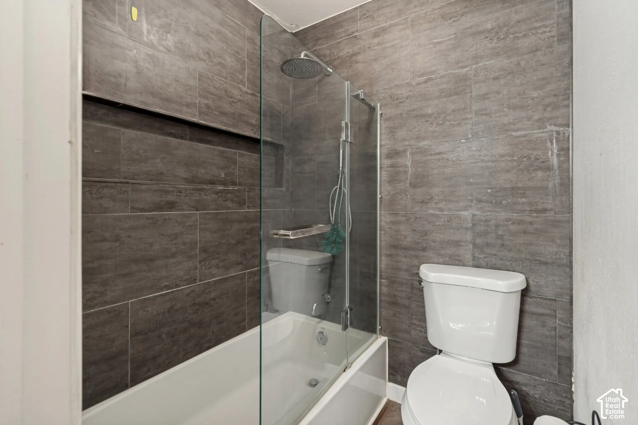 Tiled bath/shower combination with glass enclosure and rainfall showerhead