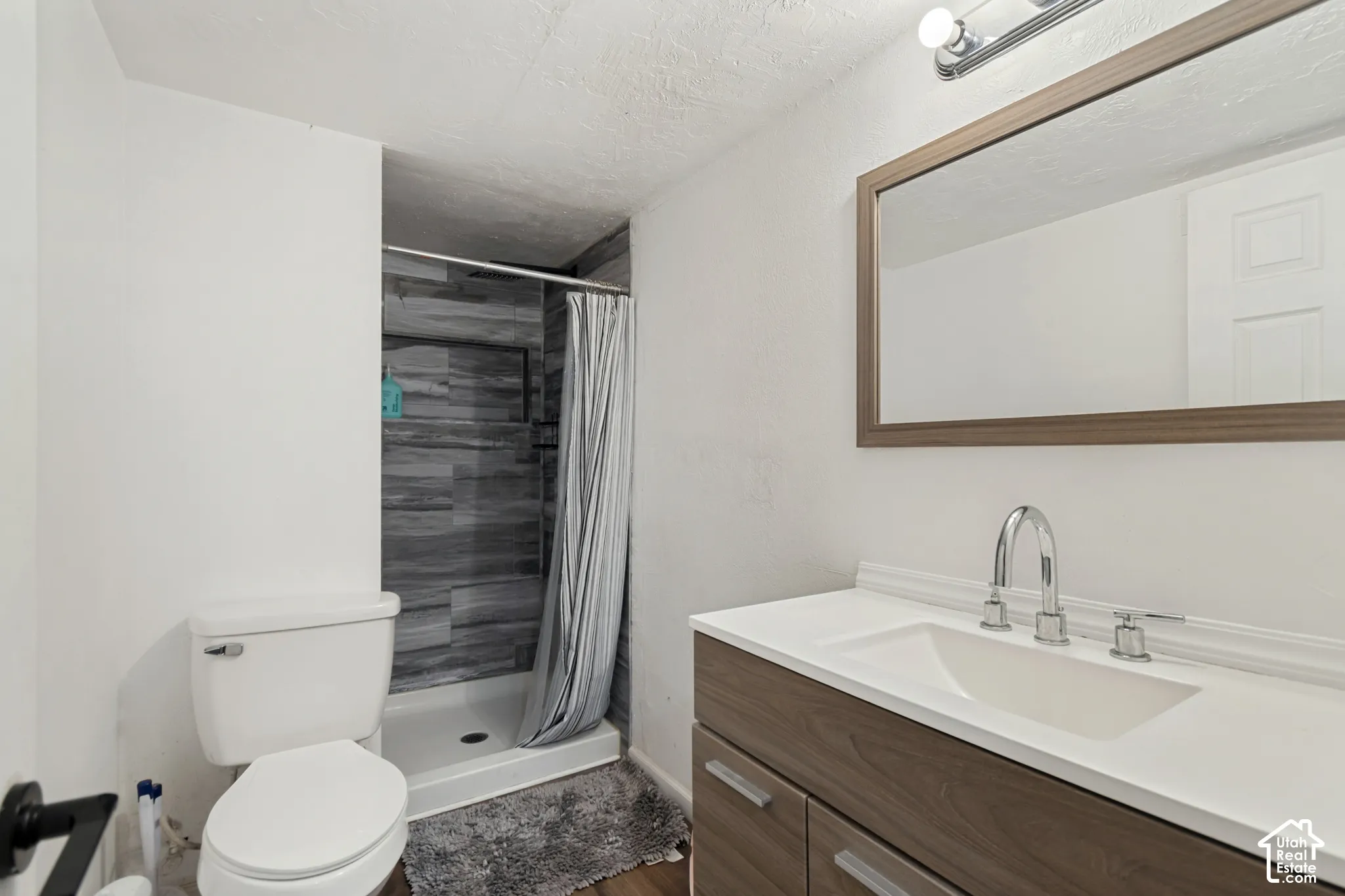 Modern vanity with wood-finish cabinetry and a white countertop