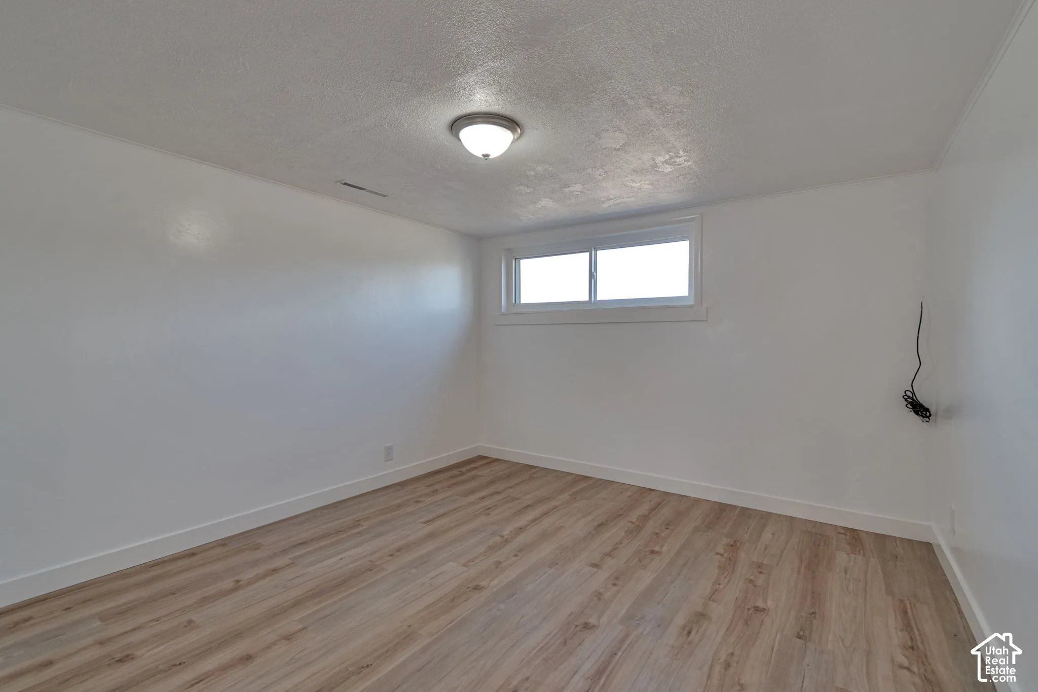 Recessed window with white trim, wood-finish flooring, white walls, and a ceiling-mounted light fixture