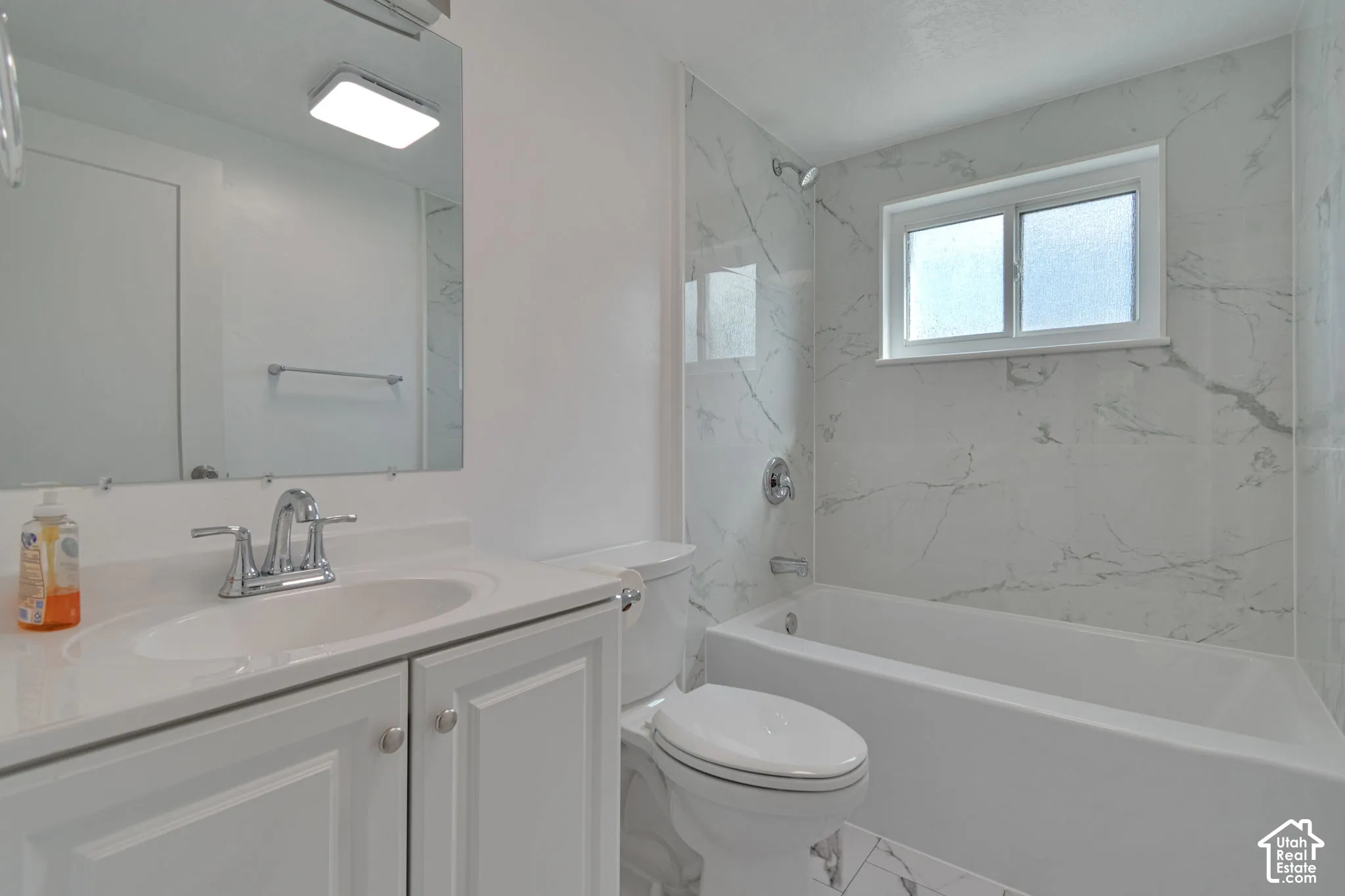 White bathroom vanity with built-in sink and chrome faucet