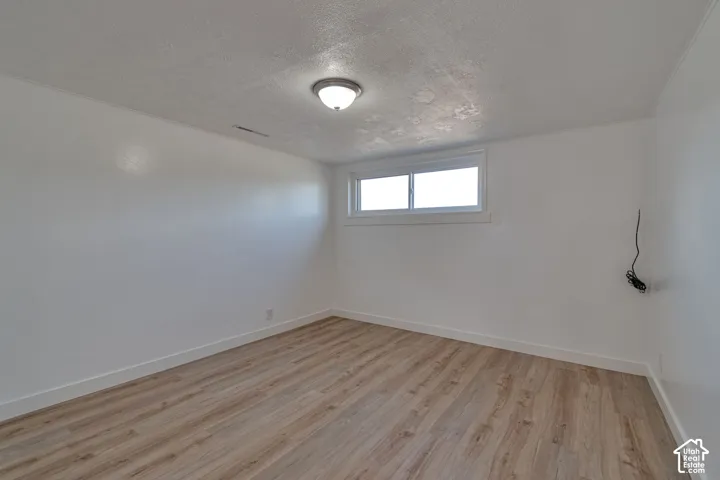Recessed window with white trim, wood-finish flooring, white walls, and a ceiling-mounted light fixture