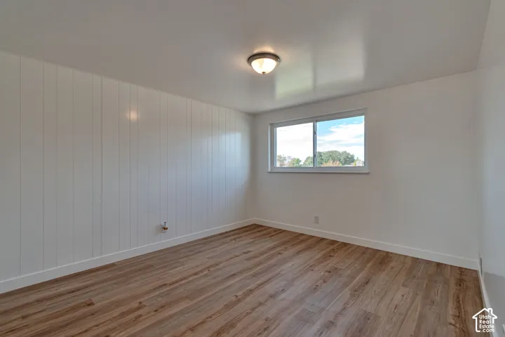 Wood-finish flooring, white walls, and a window providing natural light