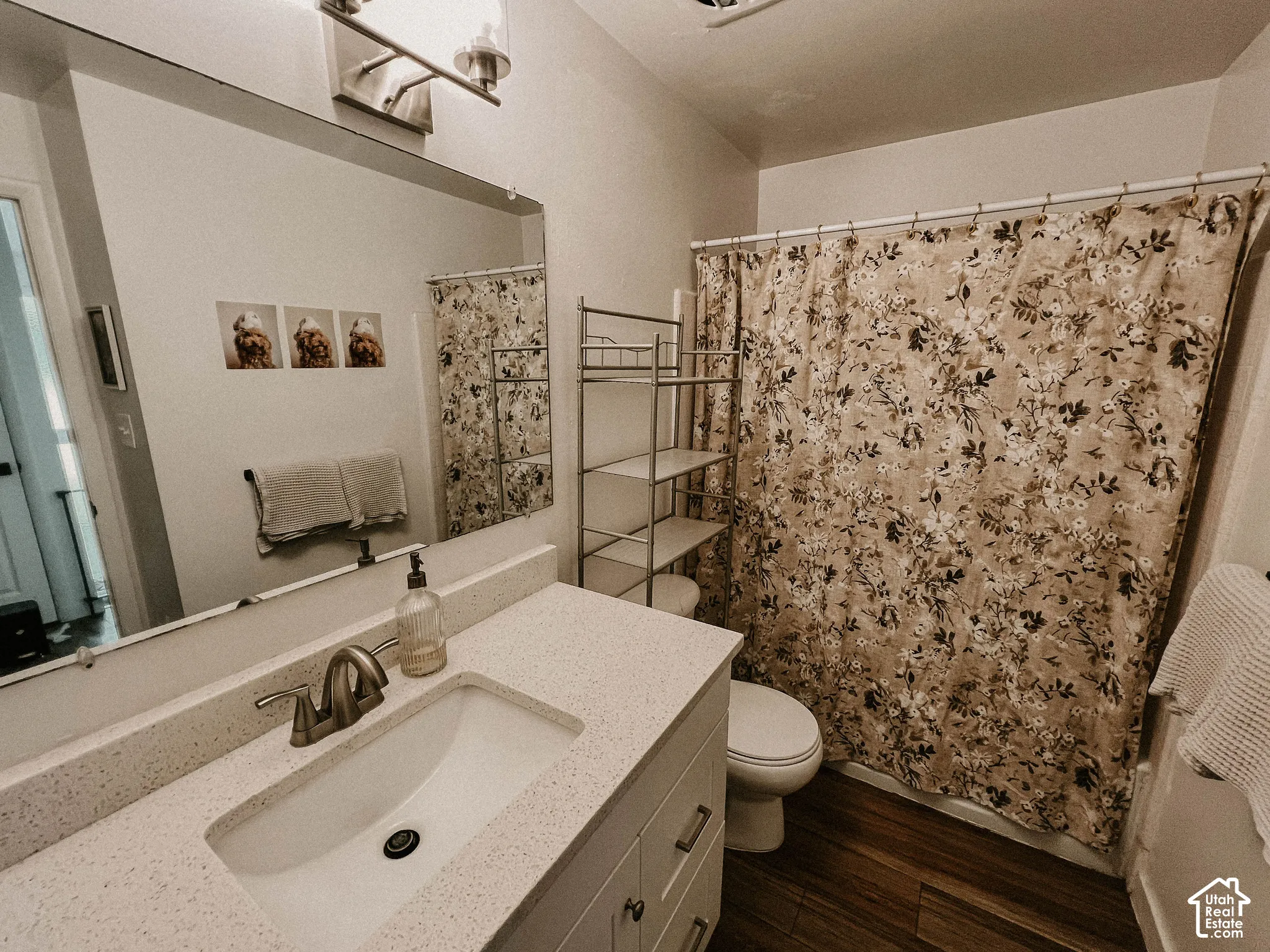 White vanity with an integrated sink, brushed nickel faucet, and composite countertop