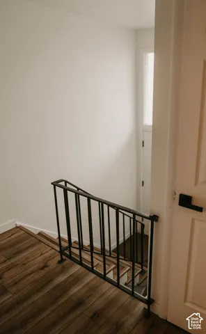 Wood-finish flooring, white walls, and a black metal railing