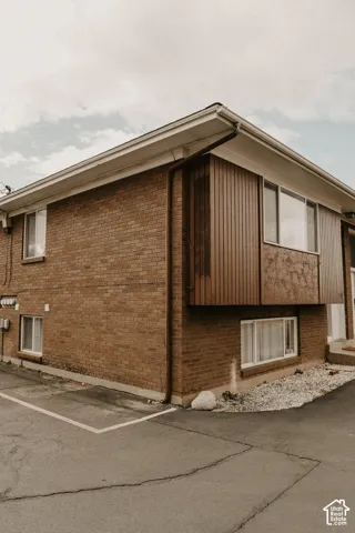 Brick exterior with wood-finish paneling and white window frames