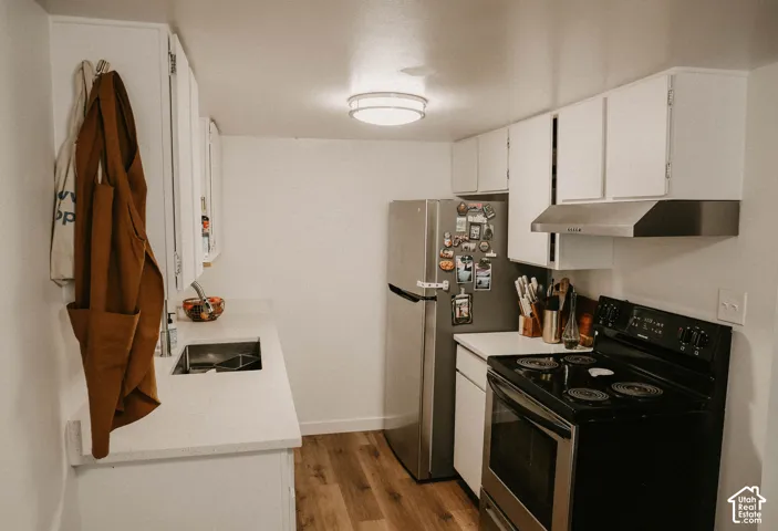 White cabinetry and countertops with wood-finish flooring