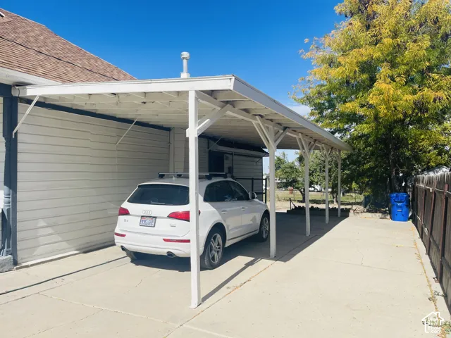 Attached carport with a concrete driveway and vinyl siding