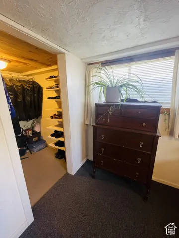 Built-in closet with multiple shelves, recessed lighting, and wood-finish ceiling