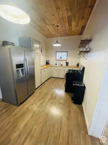 Wood-finish flooring with a wood plank ceiling and recessed lighting