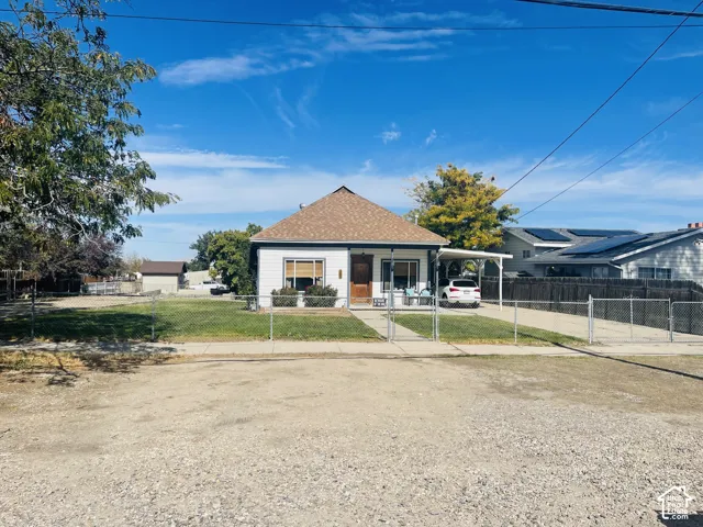 Single-story residence with light-colored siding and a brown shingle roof