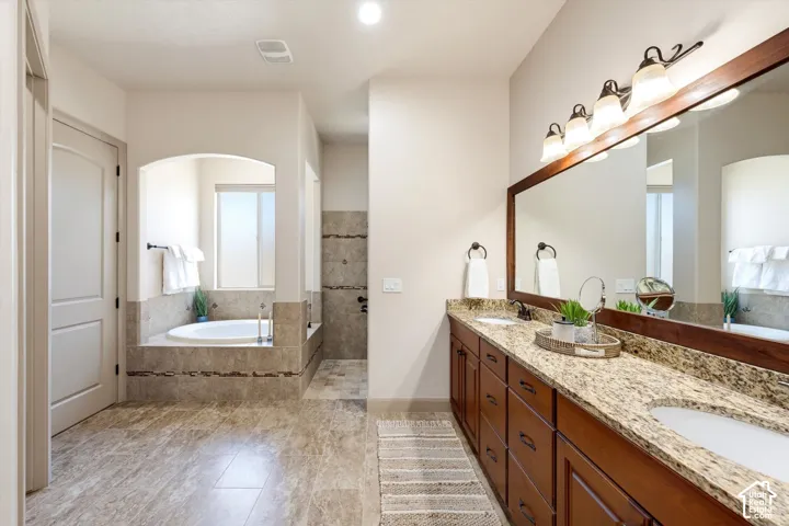 Dual vanity with integrated sinks, granite countertop, and wood-finish cabinetry