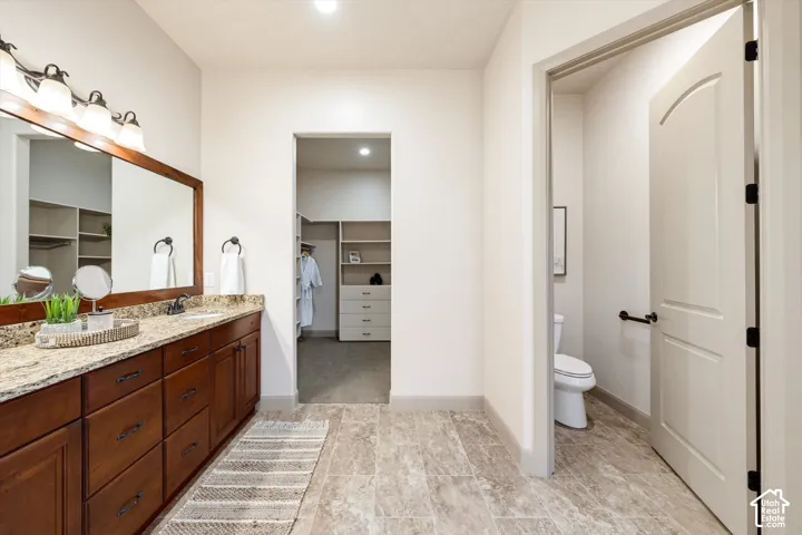 Double vanity with wood-finish cabinetry and stone countertop