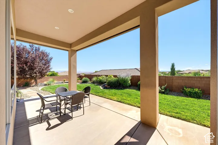 Covered patio with recessed lighting, concrete flooring, and a manicured lawn
