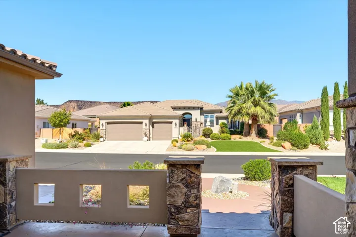Stone-clad entry pillars, decorative wall cutouts, and a paved walkway lead to a stucco exterior
